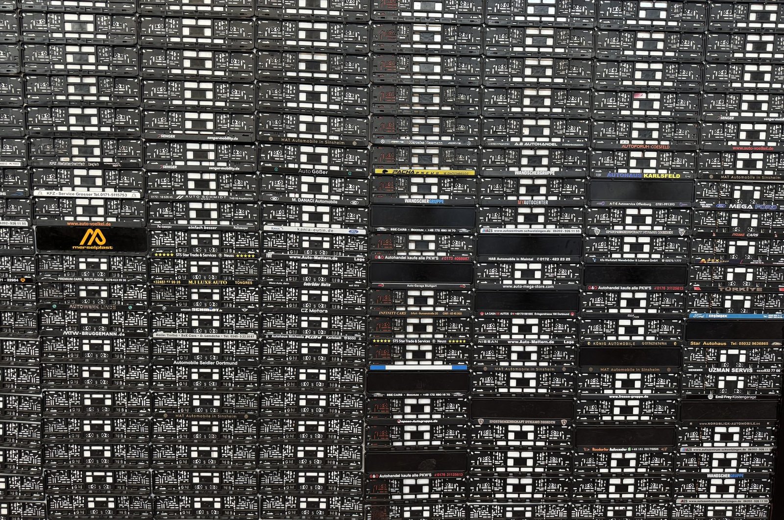 Referenzwand mit zahlreichen individuell bedruckten GSB-PLAST Kennzeichenhaltern